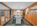 Elegant dining area features wood paneling, a stylish light fixture, and a glass-top table for modern dining experiences at 312 Palencia Pl, Lakeland, FL 33803