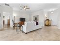 Cozy living room with neutral tones, tile floors, ceiling fan and view into the dining and Gathering room at 3136 Langdon Ln, Winter Haven, FL 33884