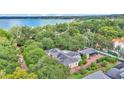 Expansive aerial view of a beautiful home nestled among lush trees, with a lake in the distance at 323 E Belvedere St, Lakeland, FL 33803
