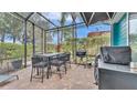 Screened patio with outdoor dining set, grill, and lush landscaping offers space for entertaining at 3243 Red Tail Hawk Dr, Polk City, FL 33868