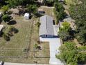 An aerial view of fenced-in property with shed, patio, and lush surrounding greenery at 355 E Columbia St, Lake Alfred, FL 33850