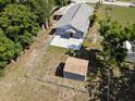 View of fully fenced backyard with shed and patio at 355 E Columbia St, Lake Alfred, FL 33850