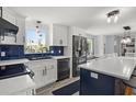 Bright kitchen featuring stainless steel appliances, white cabinets, and a dark blue tile backsplash at 3810 Harrelson Rd, Lakeland, FL 33810