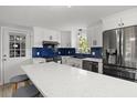 Modern kitchen featuring white cabinets, stainless steel appliances, and a blue backsplash at 3810 Harrelson Rd, Lakeland, FL 33810