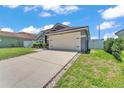 Well-maintained single-story home with a wide driveway leading to an attached two-car garage at 420 Sir Phillips Dr, Davenport, FL 33837
