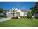 Charming single-story home featuring a well-manicured lawn and a two-car garage at 4303 Moon Shadow Loop, Mulberry, FL 33860