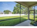 Covered screened patio with a view of the home's lush backyard and white privacy fence at 4303 Moon Shadow Loop, Mulberry, FL 33860