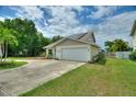 Inviting single-story home with a two-car garage, solar panels, light blue front door, and green lawn at 440 Lake Daisy, Winter Haven, FL 33884