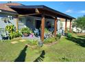 Charming backyard patio with wooden pergola, perfect for outdoor relaxation and entertaining, plus lush greenery at 455 Eagle Dr, Kissimmee, FL 34759