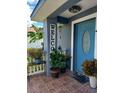 Inviting front porch with a decorated blue front door, potted plants, and a welcome sign at 455 Eagle Dr, Kissimmee, FL 34759