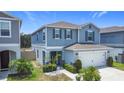 Inviting two-story home with a two-car garage, charming landscaping, and covered front entry at 511 Preserve Pointe Blvd, Davenport, FL 33837