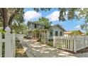 Inviting light blue two-story home with a white picket fence and mature trees at 516 Windsor St, Lakeland, FL 33803