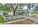 Beautiful light blue two-story home with a white picket fence, lush yard and a detached garage at 516 Windsor St, Lakeland, FL 33803