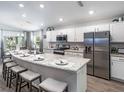 Beautiful kitchen featuring a large center island with seating, stainless steel appliances, and stylish white cabinetry at 5424 Se 127Th Ln, Belleview, FL 34420