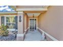 Inviting front porch with decorative pineapple, bird bath, and lush landscaping at 555 Heather Glen Dr, Winter Haven, FL 33884