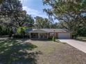Welcoming single-story home with a lovely front lawn, a covered porch with rocking chairs, and mature shade trees at 5624 Laurel Oak Dr, Lakeland, FL 33811