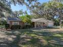 Attractive brick home showcasing a cozy front porch with rocking chairs, complemented by lush landscaping and a well-kept lawn at 5624 Laurel Oak Dr, Lakeland, FL 33811