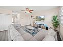 Comfortable living room features a large gray sectional, ceiling fan, and modern decor at 5793 Dornich Dr, Auburndale, FL 33823