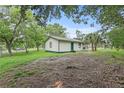 Quaint single-story home with green trim, a fenced yard, and mature trees at 633 Glenda St, Lakeland, FL 33805