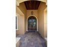 Covered front entrance features an arched wood door with decorative metalwork and brick paving at 6357 Ashley Dr, Lakeland, FL 33813