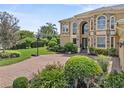 Beautifully landscaped yard with lush green grass and a brick driveway with basketball hoop at 6542 Eagle Ridge Way, Lakeland, FL 33813