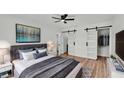 Serene main bedroom with gray accents, wood floors, and sliding barn doors at 6543 Tula Ln, Lakeland, FL 33809