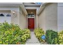 Inviting front entrance with a bright red door, decorative plants, and an ADT security sign at 1003 Clearpointe Way, Lakeland, FL 33813