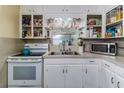 Functional kitchen with white cabinetry, matching appliances, and ample counter space at 102 Pike St, Auburndale, FL 33823