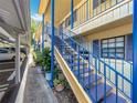Condo building exterior showcasing stairways with blue railings, and lush landscaping at 110 N Tremain St # 206, Mount Dora, FL 32757