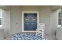 Inviting front door with double doors, rocking chair, and stylish outdoor rug at 1146 Enclave Ct., Auburndale, FL 33823