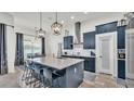 Stylish kitchen with stainless steel appliances, large island, and modern pendant lighting at 1146 Enclave Ct., Auburndale, FL 33823