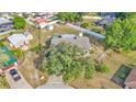 Aerial view of a home with a backyard, storage sheds, partial white fence, and mature trees surrounded by neighborhood at 1423 Ridgegreen N Loop, Lakeland, FL 33809