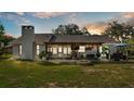 Inviting backyard with covered patio, fire pit, outdoor seating, grill, and mature shade trees perfect for entertaining at 1423 Ridgegreen N Loop, Lakeland, FL 33809