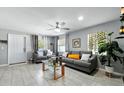Inviting living room with tile flooring, gray sofas, and a ceiling fan for comfortable living at 1648 Skinner St, Lakeland, FL 33801