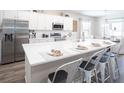 Modern kitchen with an oversized white quartz countertop island, stainless steel appliances, and white cabinets at 1823 Daystar Dr, Haines City, FL 33844