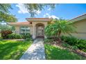 Inviting home entrance with a well-maintained lawn, manicured shrubbery, and a tiled roof at 188 Morning Dew Ct, Winter Haven, FL 33884