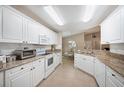 Well-lit kitchen features granite countertops, white cabinets, tile flooring, and modern appliances at 188 Morning Dew Ct, Winter Haven, FL 33884