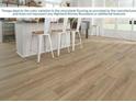 Durable vinyl plank flooring with neutral tones complements a modern kitchen and seating area at 1906 Daystar Dr, Haines City, FL 33844