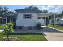 View of the side of a single-story home with carport, stone flower beds and well-maintained lawn at 2005 Blue Lake Dr, Lakeland, FL 33801