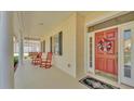 Inviting front porch with red rocking chairs, patriotic wreath, and double front doors at 2025 Viewpoint Landings Rd, Lakeland, FL 33810