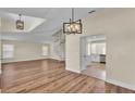 Open-concept living room featuring wood laminate flooring, spiral staircase, and modern light fixtures at 2255 Couples Dr, Lakeland, FL 33813