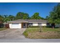 Inviting single-story home with a manicured front lawn, attached garage, and charming curb appeal at 2757 Pine Acres Dr, Lake Wales, FL 33898