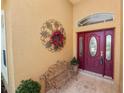 Close-up of the front door featuring decorative wreath and bench on the tiled porch at 2936 Grasslands Dr, Lakeland, FL 33803