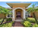 Inviting front entrance with covered porch, decorative columns, and lush landscaping at 2936 Grasslands Dr, Lakeland, FL 33803