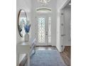 Elegant entryway with decorative glass door, modern light fixture, and stylish mirror at 3176 Pearly Dr, Lakeland, FL 33812