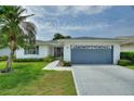 Charming single-story home with a well-manicured lawn and attached blue two-car garage at 3618 Highland Fairways Blvd, Lakeland, FL 33810