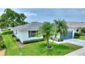 A single-story home surrounded by lush green grass and palm trees, with a well-kept lawn at 3618 Highland Fairways Blvd, Lakeland, FL 33810