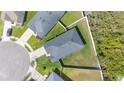 Overhead view of a gray roofed house with a manicured backyard and nearby neighboring homes at 3883 Sandhill Crane Dr, Lakeland, FL 33811