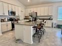 Bright kitchen with stainless steel appliances, center island with bar stool seating, and gray countertops at 3966 Willowbrook Dr, Edgewater, FL 32141