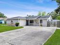 Appealing ranch-style home with a well-kept lawn, long driveway, and neutral gray color scheme at 417 El Salvador Dr, Lakeland, FL 33809